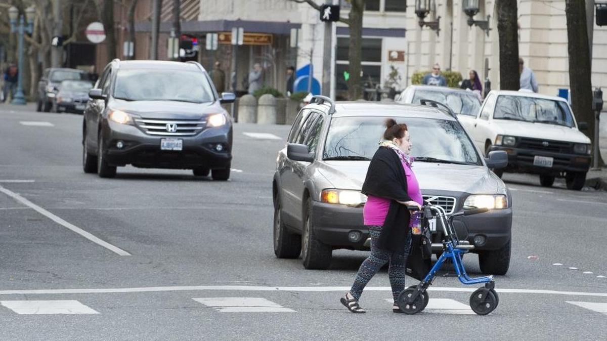 A pedestrian crosses Magnolia Street in downtown Bellingham. Some cities have adjusted their balance between traffic efficiency and safety by changing speed limits from 25 mph to 20 mph.