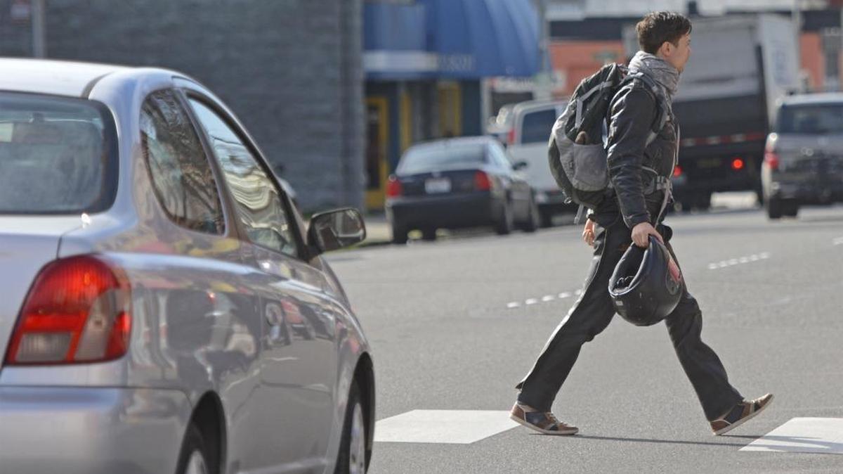 Cars stop while a pedestrian crosses North State Street at East Maple Street, in Bellingham in February 2016. More pedestrians are struck by automobiles in marked crosswalks than unmarked crosswalks, partly because they feel like they’re in a force field.