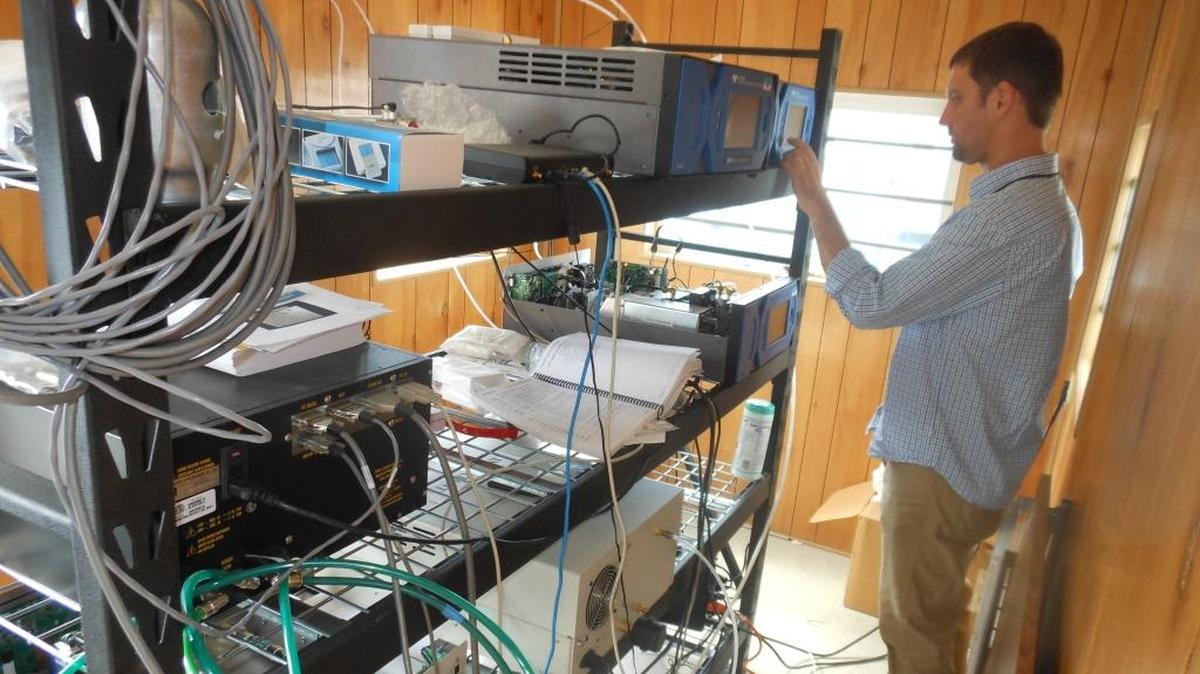 
Northwest Clean Air Agency’s Jason Bouwman works on an ozone monitor at the agency’s Anacortes monitoring station.
