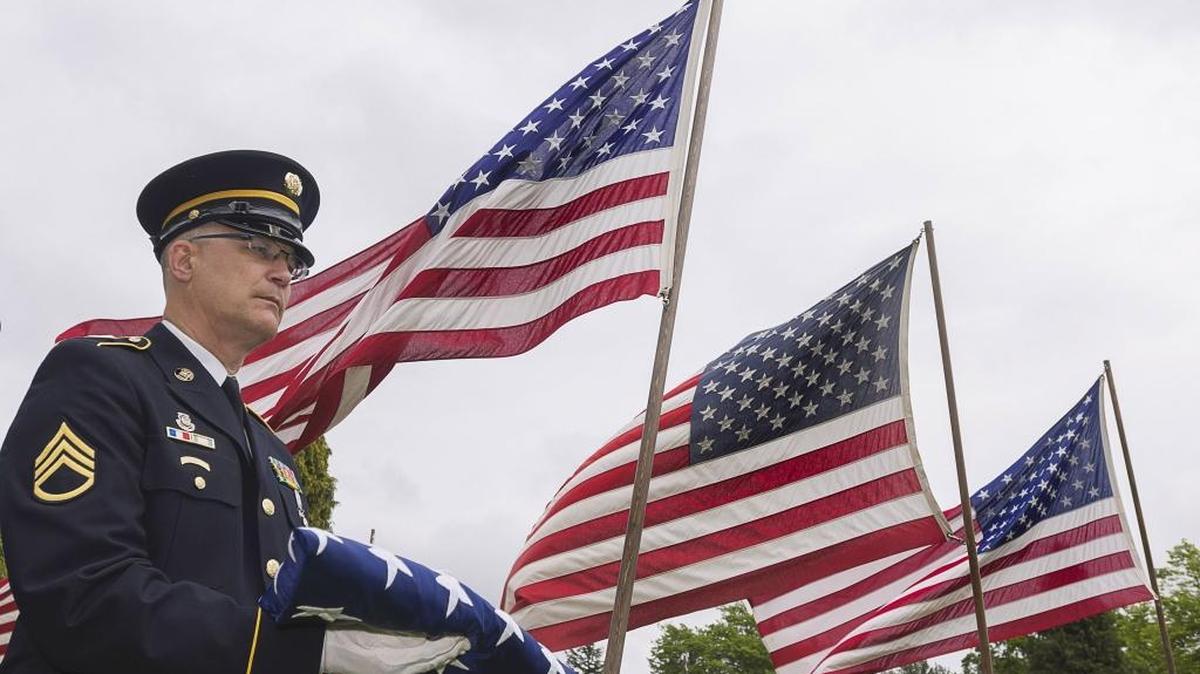 SSgt. Scott Rauch of Bellingham holds a folded U.S. flag proior to the official flag raising during the 50th annual Festival of Flags and Remembrance Ceremony at Greenacres Memorial Park in Ferndale, Wash., on Monday afternoon May 25, 2015.
