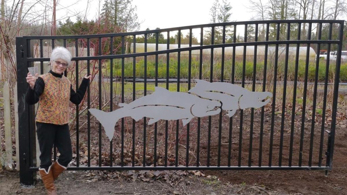 Elaine McRory, Nooksack Salmon Enhancement Association campaign committee member and long-time salmon restoration supporter, at the entrance gate of the organization’s new permanent home.