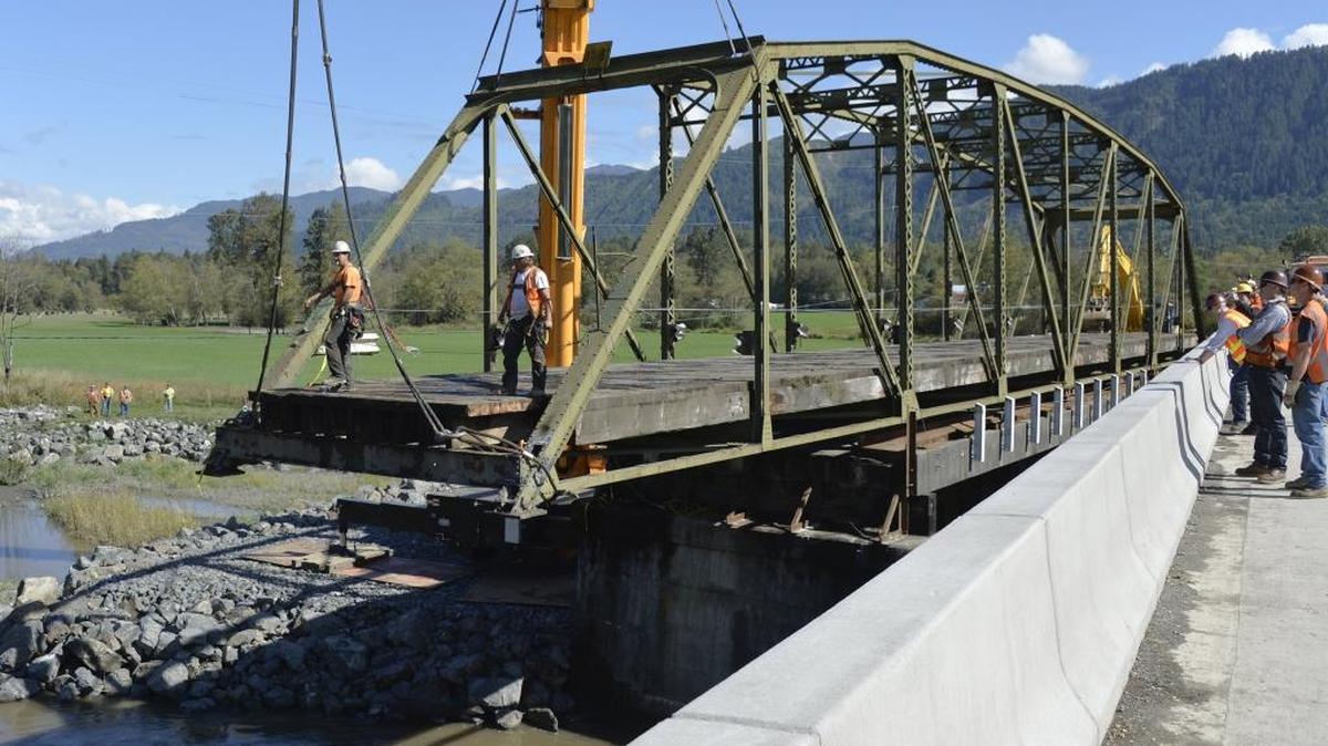 Workers slide back the old Potter Road bridge from over the south fork of the Nooksack River Sept. 21, 2015, west of Van Zandt. The old one-lane bridge, replaced by a new two-lane bridge, will be taken apart and removed. The project was completed for an October ribbon cutting.