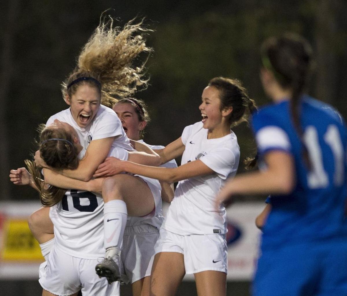 Squalicum's Kim Hazlett jumps into the arms of teammate Kim Dorr after scoring a goal against Ridgefield in the WIAA 2A State Girls' Soccer Tournament championship game on Friday, Nov. 20, at Shoreline Stadium in Shoreline, Wash. Hazlett and Dorr, both seniors, lead the Storm to a second consecutive state championship with a combined 66 goals between the two this season.