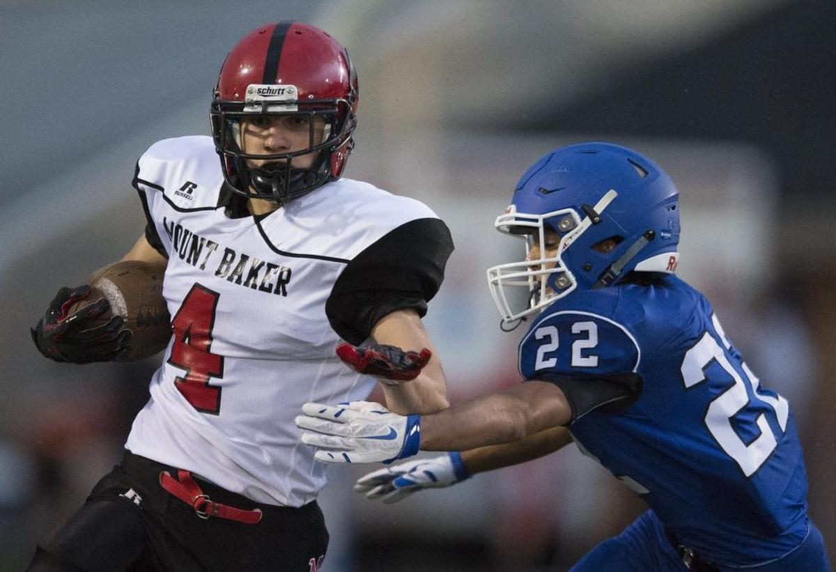 Mount Baker's Jed Schleimer runs through an attempted tackle by Sedro-Woolley's Thor Wagnor on Friday, Sept. 4, at Sedro-Woolley High School in Sedro-Woolley, Wash.