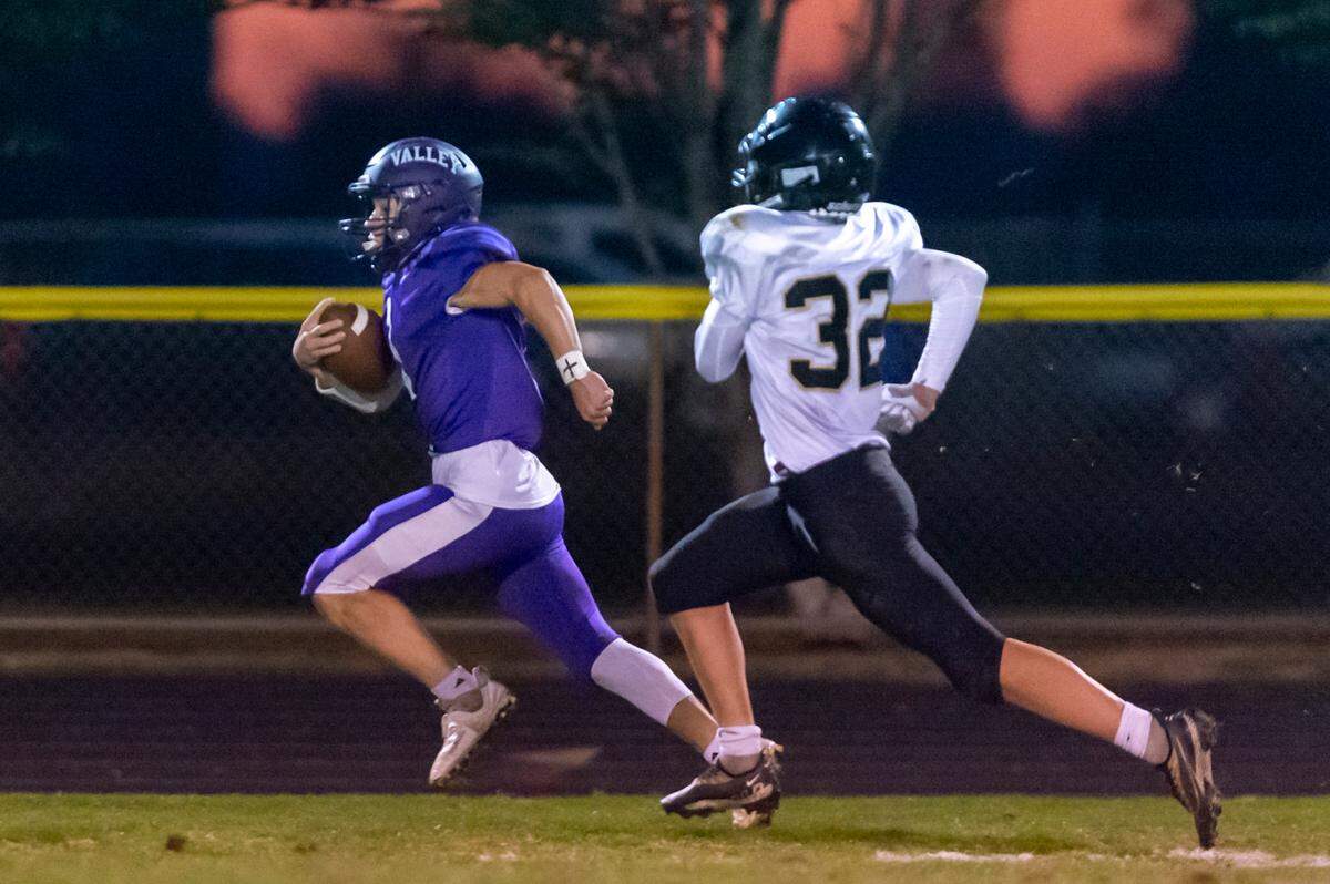 Meridian defender Landen Downey (32) chases Nooksack Valley wide receiver Jackson Bennett (1) as he runs down the sideline to score a first quarter touchdown on Friday evening Sept. 30, at Nooksack Valley High School in Everson.