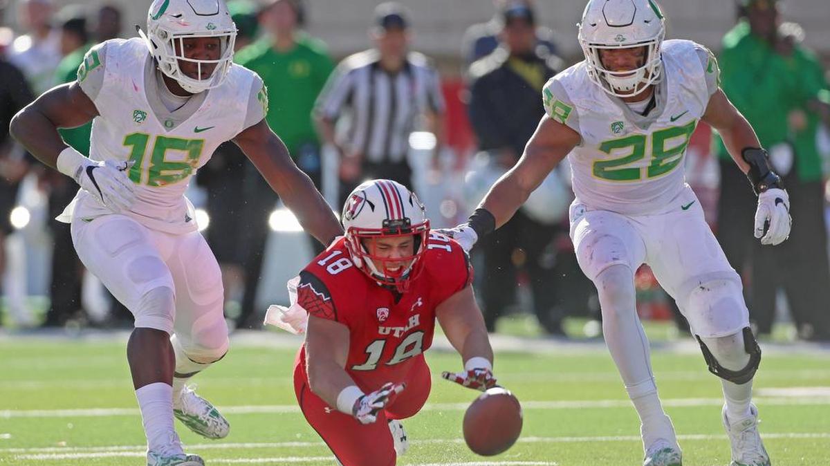 Utah’s Evan Moeai , middle, drops a pass between Oregon’s Jimmie Swain, left, and Brady Breeze in the second half. The Utes fell out of contention for the Pacific-12 Conference South championship with a 30-28 loss to the Ducks.