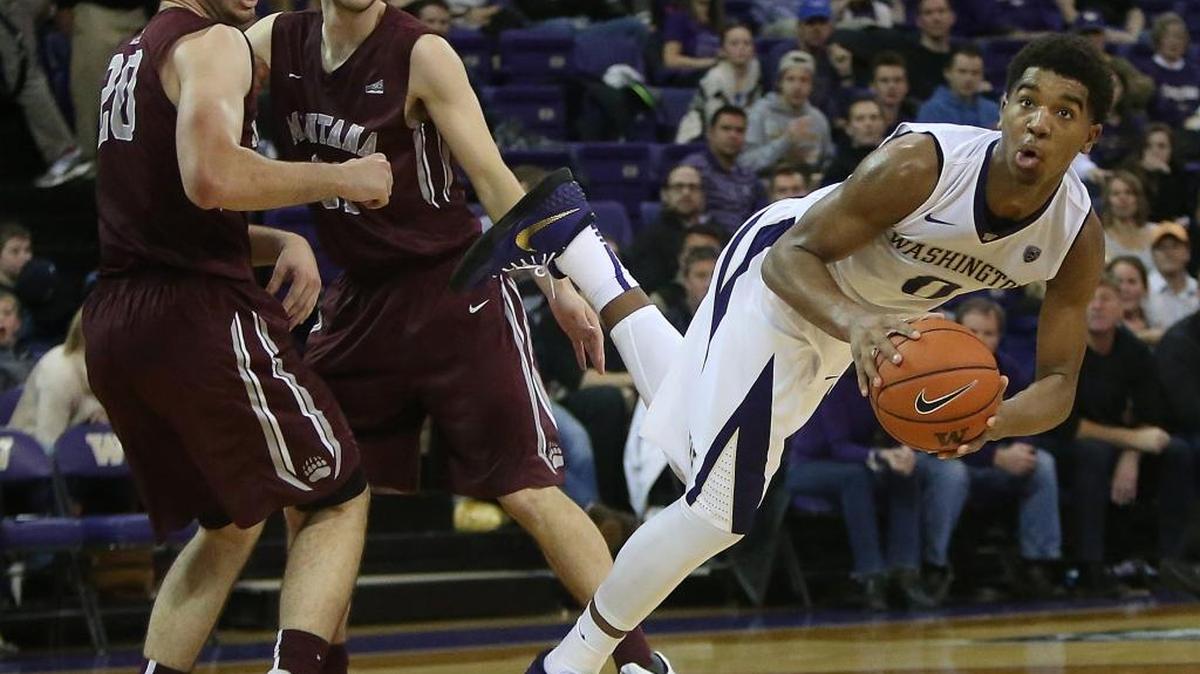 UW’s Marquese Chriss (0) falls to the court after plowing through a double team by Montana’s Fabijan Krslovic (20) and Jack Lopez. (31) on Saturday, Dec. 12, 2015, at Alaska Airlines Arena in Seattle. The host Huskies won, 92-62.