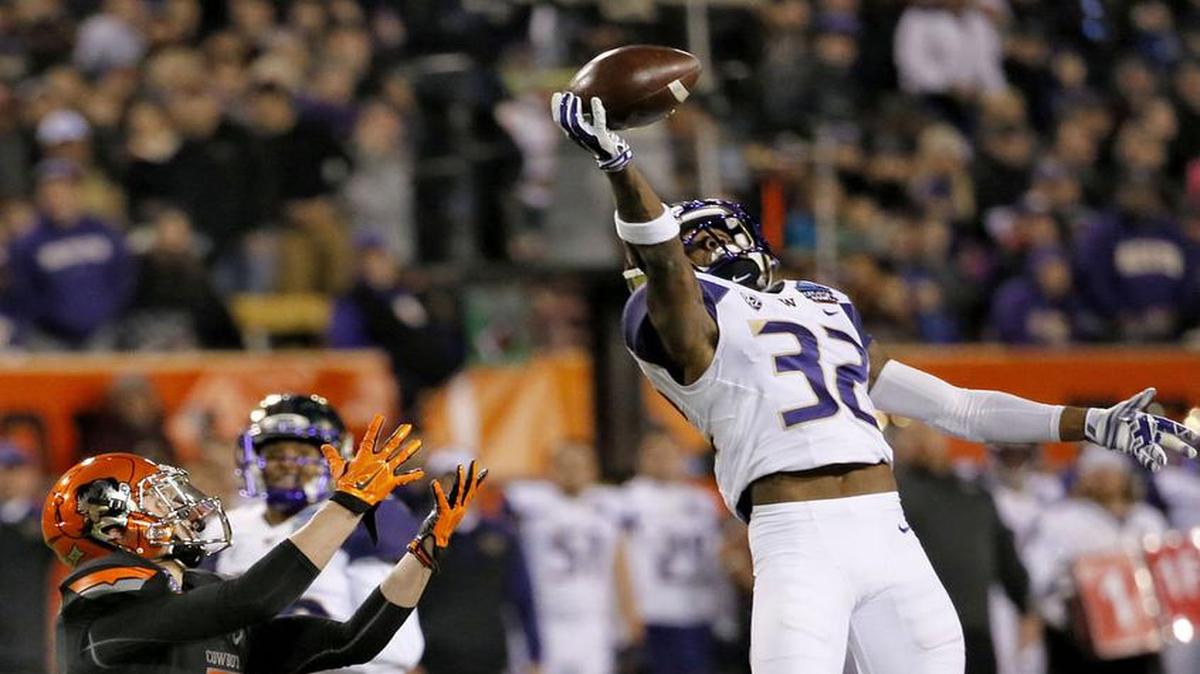 
Washington defensive back Budda Baker intercepts a pass intended for Oklahoma State wide receiver Blake Webb during the Cactus Bowl on Jan. 2, 2015, in Tempe, Ariz.

