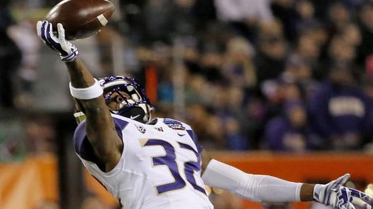 Washington defensive back Budda Baker (32) intercepts a pass intended for Oklahoma State wide receiver Blake Webb (5) during the first half of the Cactus Bowl last season.