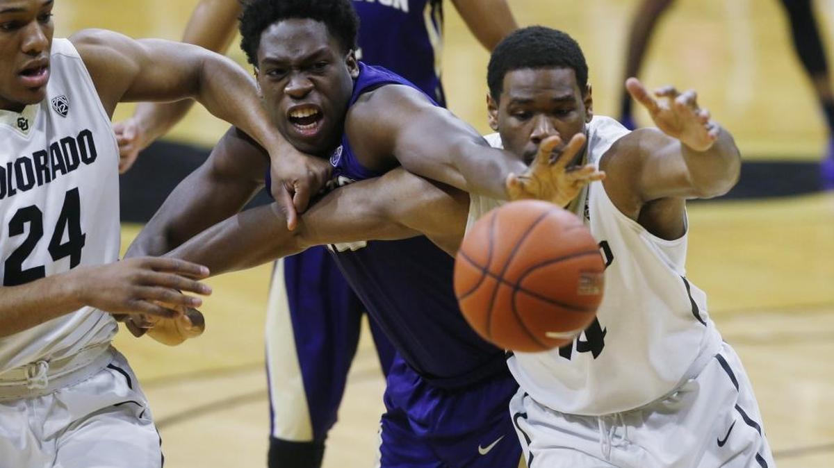 Washington forward Noah Dickerson, center, fights for control of a rebound with Colorado guard George King, left, and forward Tory Miller in the first half of an NCAA college basketball game Saturday, Feb. 13, 2016, in Boulder, Colorado.