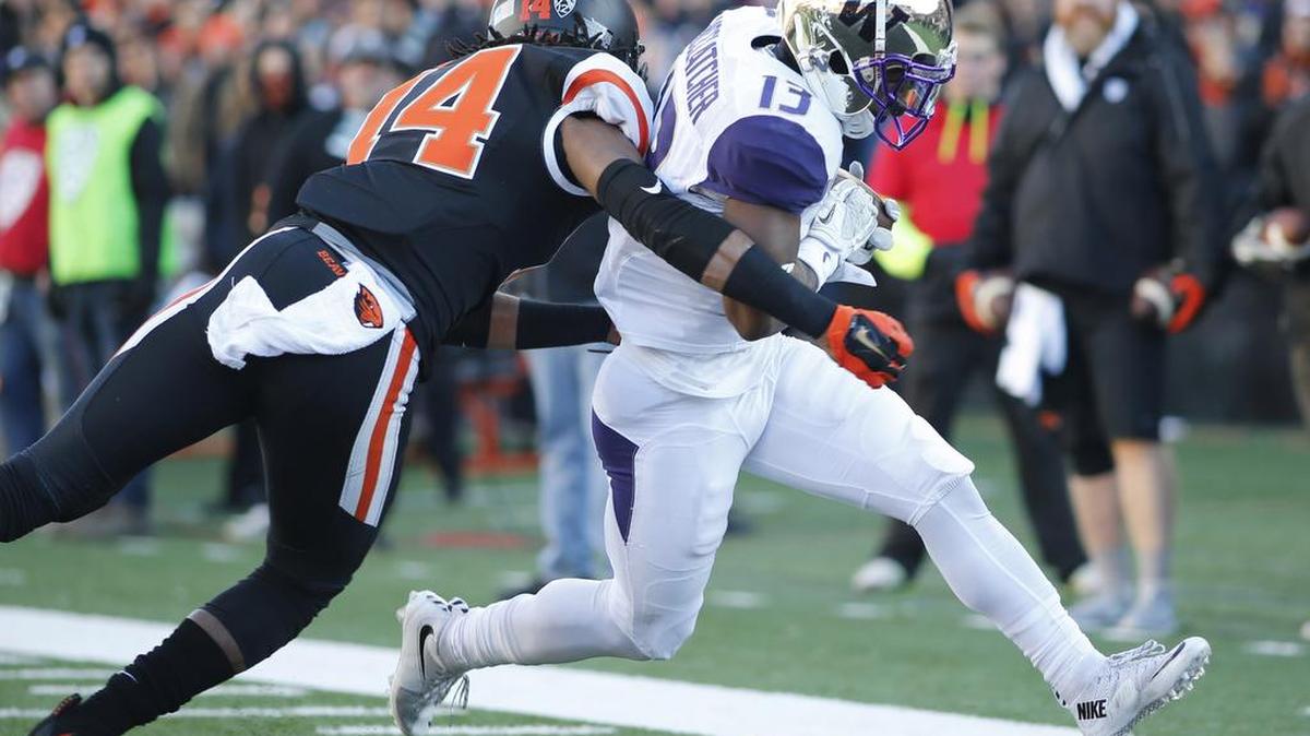 UW’s Chico McCatcher, right, gets around Oregon State’s Treston Decoud for a touchdown, giving the Huskies a 14-0 lead in the first quarter.