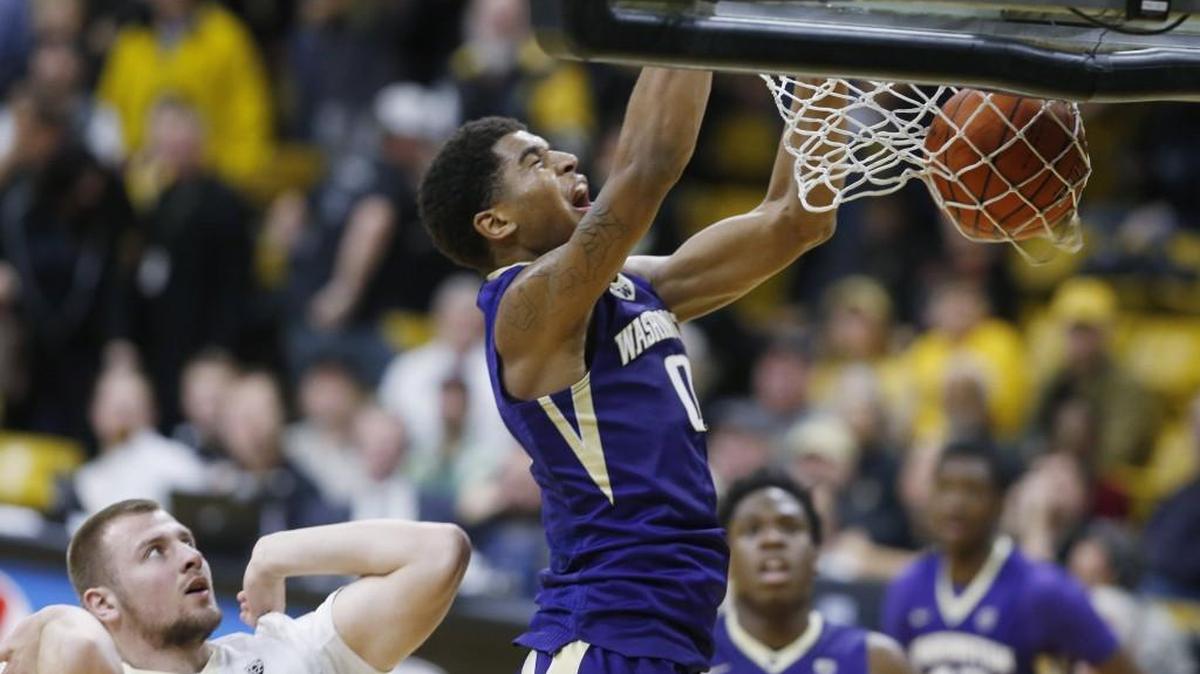 Washington forward Marquese Chriss, right, reacts as he dunks the ball for a basket over Colorado forward Kenan Guzonjic in the first half of an NCAA college basketball game Saturday, Feb. 13, 2016, in Boulder, Colo.