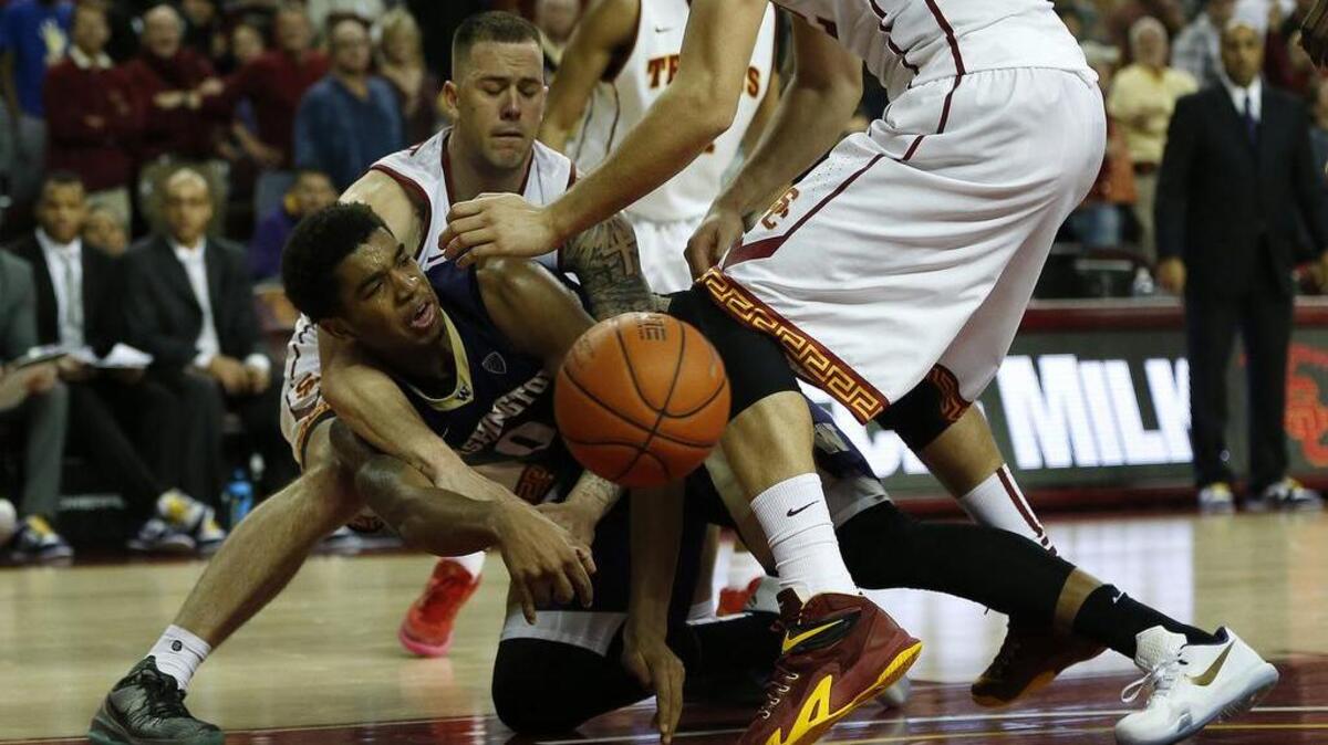 USC’s Katin Reinhardt (5) pressures Washington’s Marquese Chriss (0) to give up the ball late in the game Saturday at the Galen Center in Los Angeles. Chriss led the Huskies with 18 points.