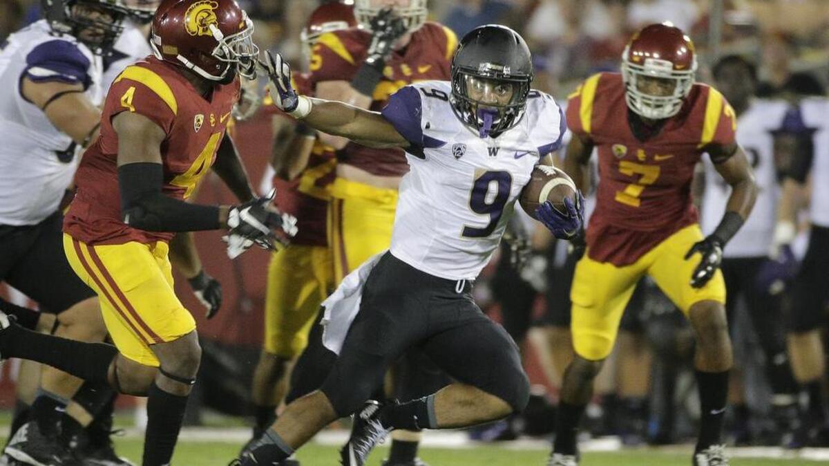 Washington's Myles Gaskin (9) carries the ball under pressure by Southern California’s Chris Hawkins on Oct. 8 in Los Angeles. Washington won 17-12.