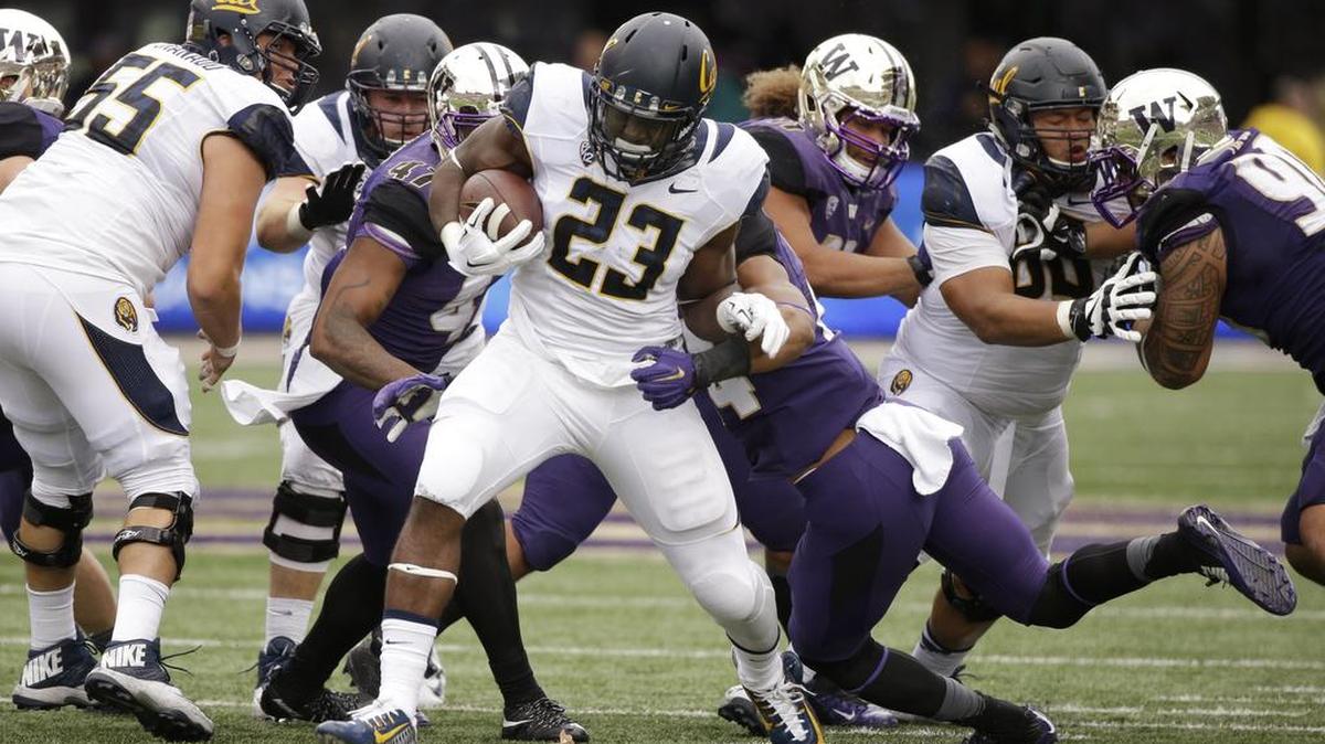 
California running back Vic Enwere tries to break free from Washington tacklers during Saturday’s game in Seattle.

