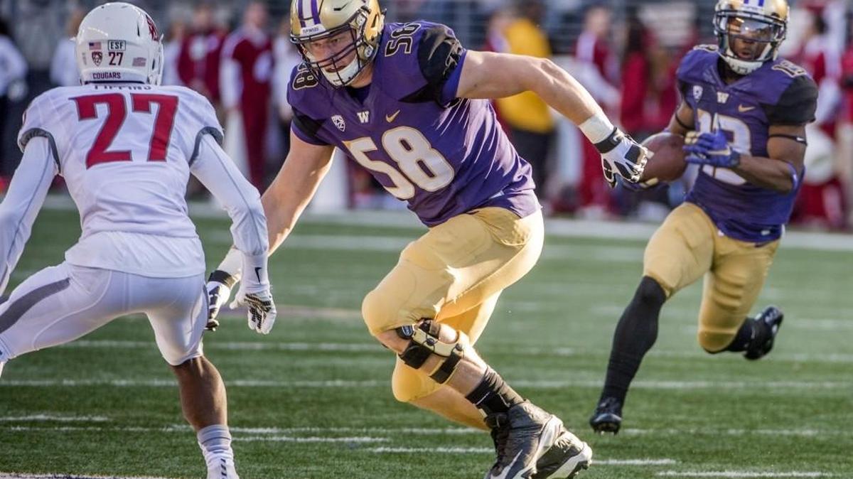 Washington’s Kaleb McGary, center, makes room for Chico McClatcher, right, to score a touchdown in last year’s Apple Cup game Nov. 27 against the WSU Cougars.