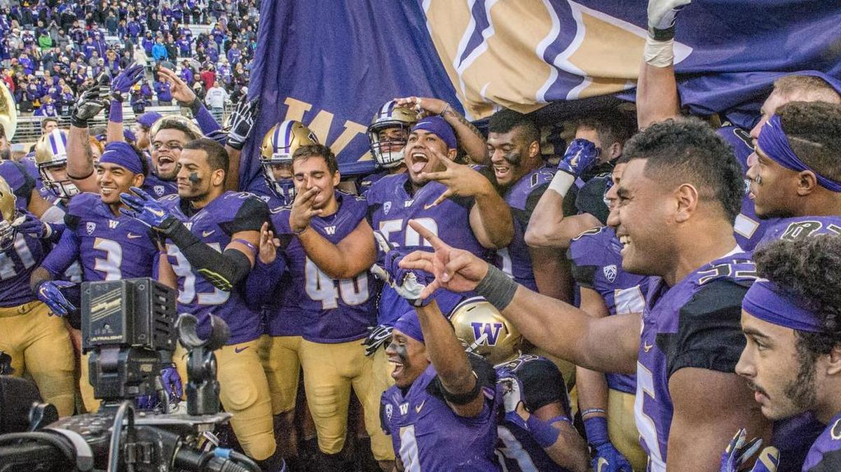 The UW Huskies football team gathers on the field of Husky Stadium Nov. 27 to celebrate its 45-10 win over the WSU Cougars in the Apple Cup.