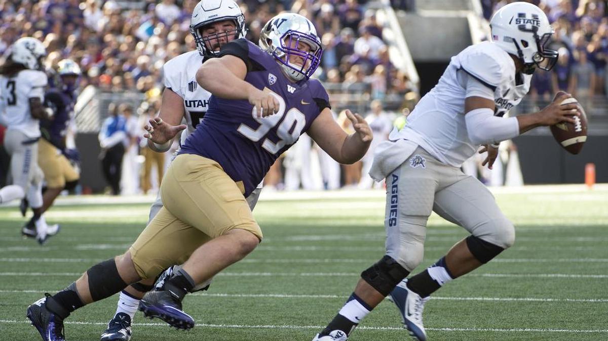 UW lineman Greg Gaines chases Utah State quarterback Chuckie Keeton. Photo taken at Husky Stadium in Seattle on Saturday, Sept. 19, 2015.
