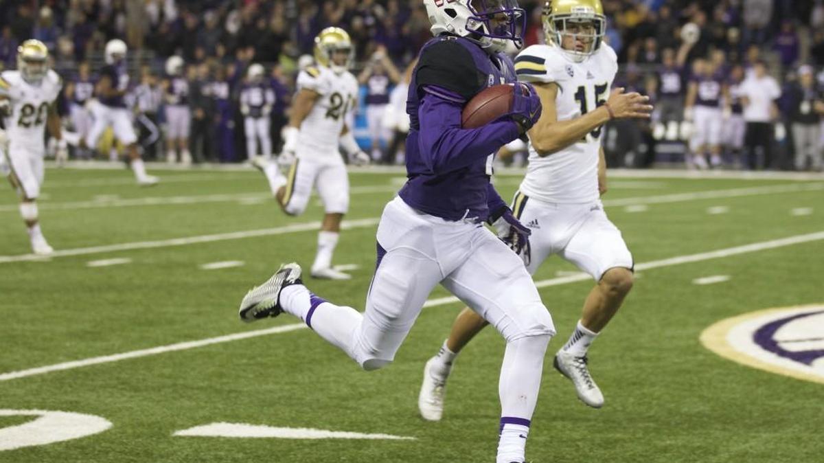 UW kick returner and wide receiver John Ross III, foreground, returns a kickoff 100 yards for a touchdown against UCLA in 2014. Ross missed last season due to a knee injury but returns in 2016.