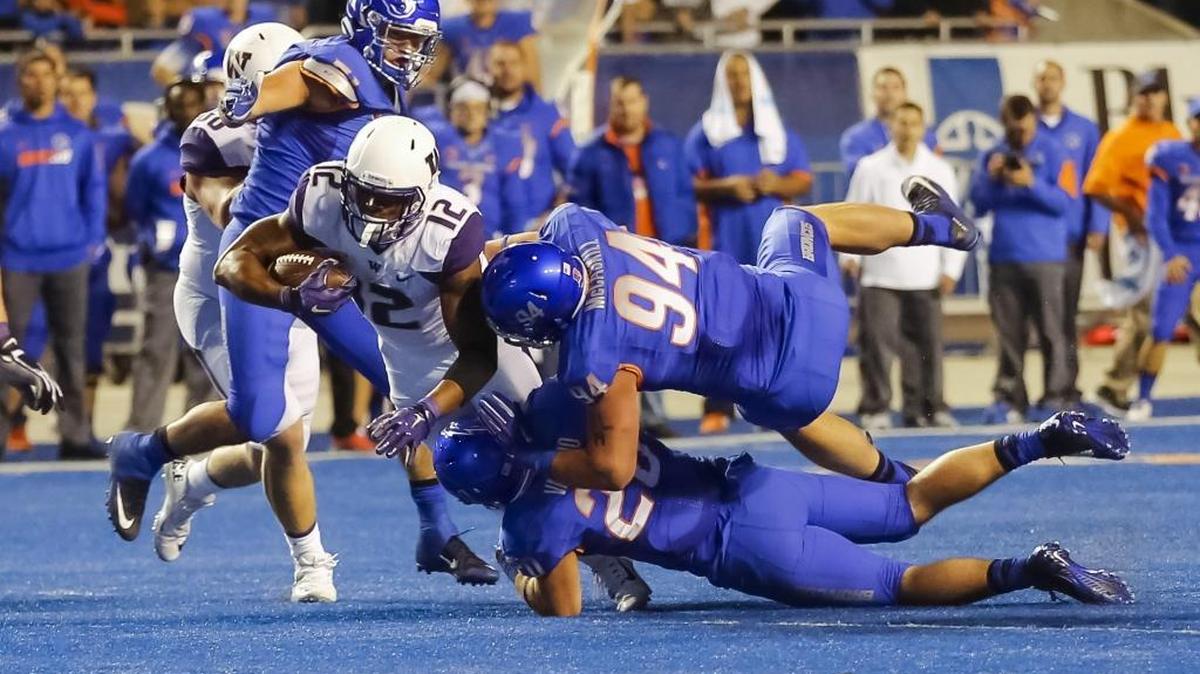 
Boise State tacklers bring down Washington running back Dwayne Washington, wearing a white jersey, during the second half of the season opener Friday in Boise. The Huskies finished with 29 rushing yards on 22 attempts.
