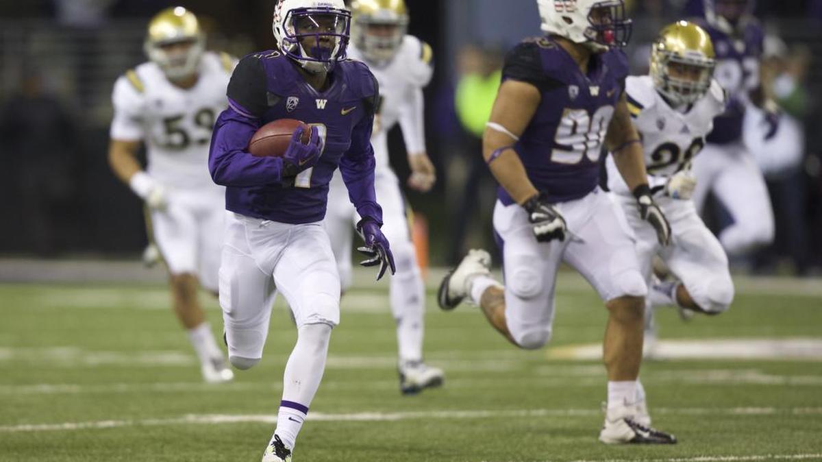 Washington returner John Ross III, front left, returns a kickoff 100 yards for a touchdown in the second half of a game vs. UCLA on Nov. 8, 2014. The Huskies lost to the Bruins, 44-30.