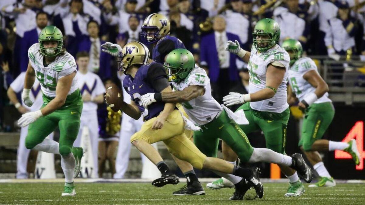 
Washington quarterback Jake Browning, center left, is tackled by Oregon linebacker Tyson Coleman (33) in the second half Saturday. Browning sat out the final few minutes with a shoulder injury. 
