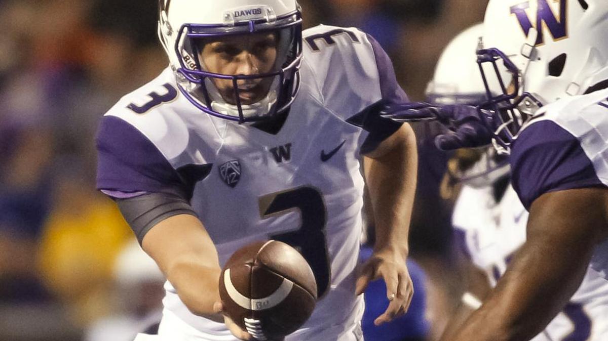 
Washington true freshman quarterback Jake Browning (3) hands the ball off during the Huskies’ first play from scrimmage against Boise State in Boise on Friday. 

