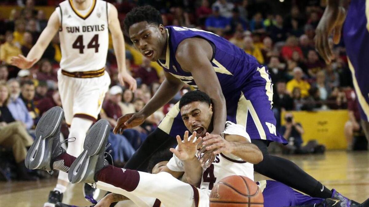 UW’s Noah Dickerson, top, attempts a steal from Arizona State’s Andre Spight on Saturday. Dickerson drew three fouls in the first half but survived to play 30 minutes, and he chipped in 10 points.