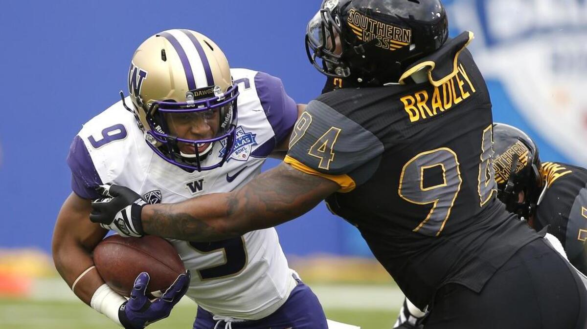 Washington fullback Myles Gaskin, left, runs against Southern Mississippi defensive lineman Dylan Bradley during the Heart of Dallas Bowl. Gaskin was named the game’s Most Valuable Player after running for a season-high 181 yards on 26 carries, scoring four touchdowns.