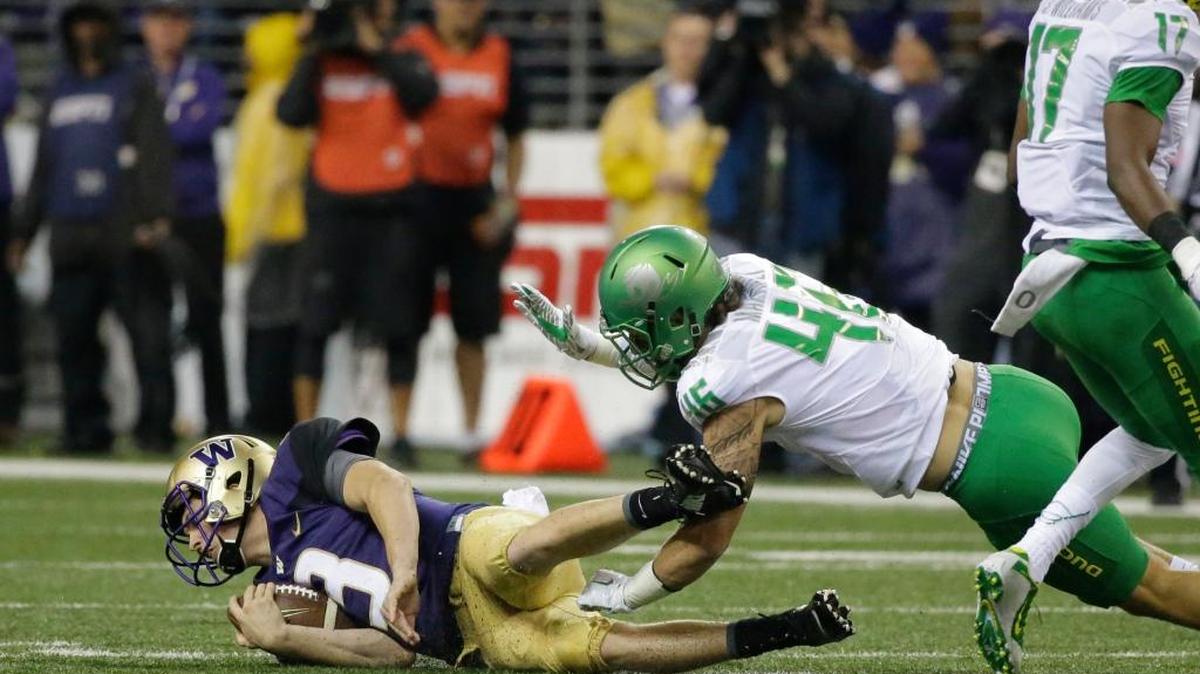 
Huskies quarterback Jake Browning is taken down by Ducks linebacker Danny Mattingly on Saturday. Browning hurt his shoulder late and missed the final UW drive.
