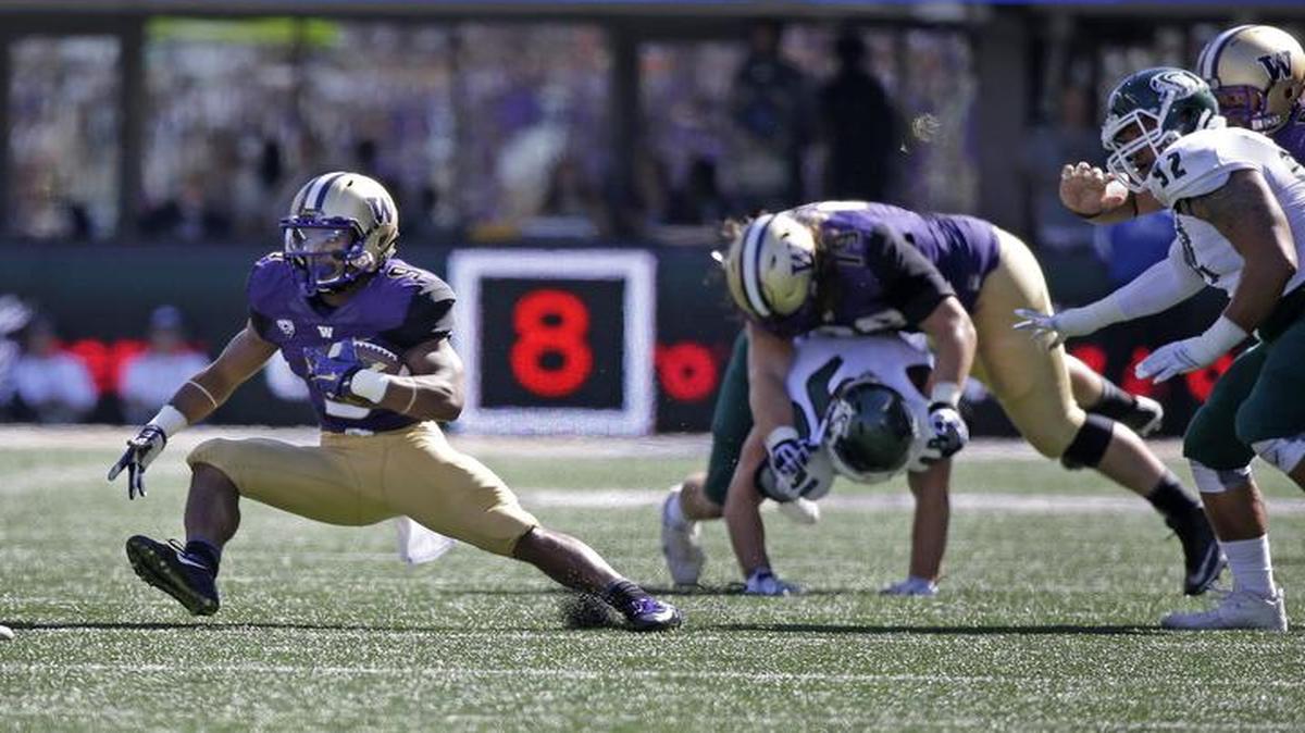 
Washington's Myles Gaskin, second left, with help from a block by another true freshman lineman, Trey Adams of Wenatchee (72), carries against Sacramento State on Saturday in Seattle.
