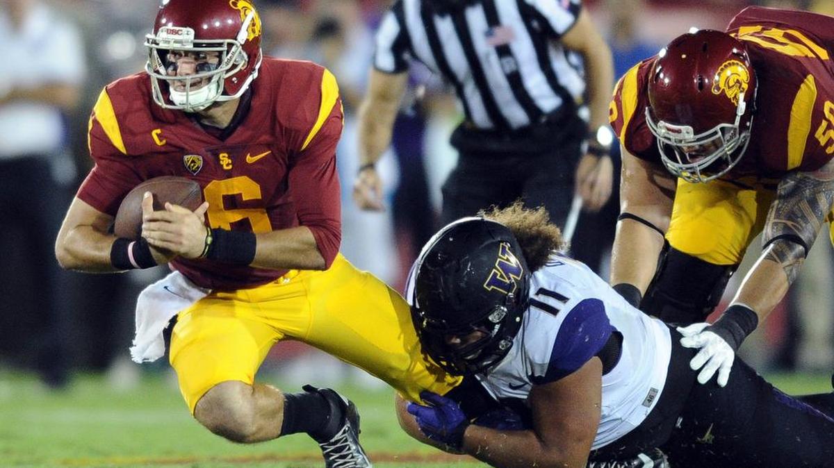 
USC quarterback Cody Kessler, left, is sacked by Washington's Elijah Qualls in the second quarter at the Los Angeles Coliseum on Thursday, Oct. 8, 2015, in Los Angeles.
