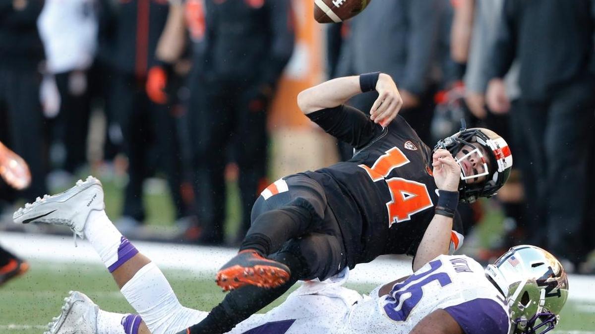 Oregon State quarterback Nick Mitchell fumbles the ball after being hit by Washington linebacker Azeem Victor on Saturday in Corvallis, Oregon.