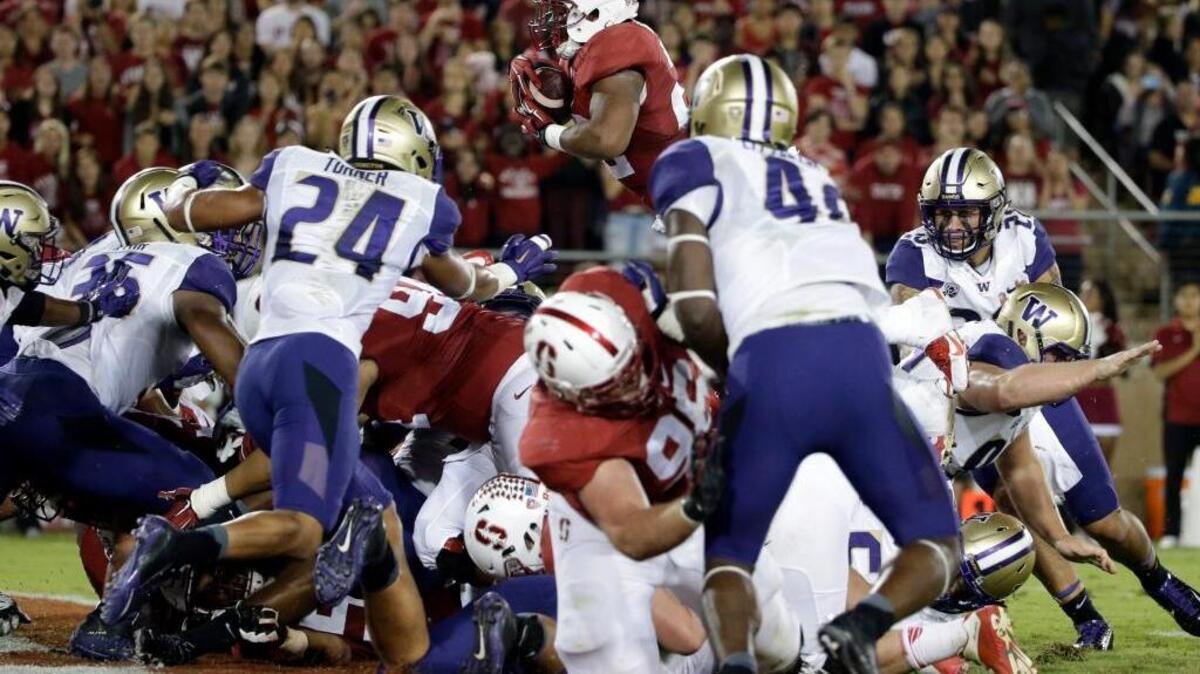 Stanford running back Remound Wright, top, leaps into the end zone for touchdown against Washington during the first half of an NCAA college football game Saturday, Oct. 24, 2015, in Stanford, Calif.