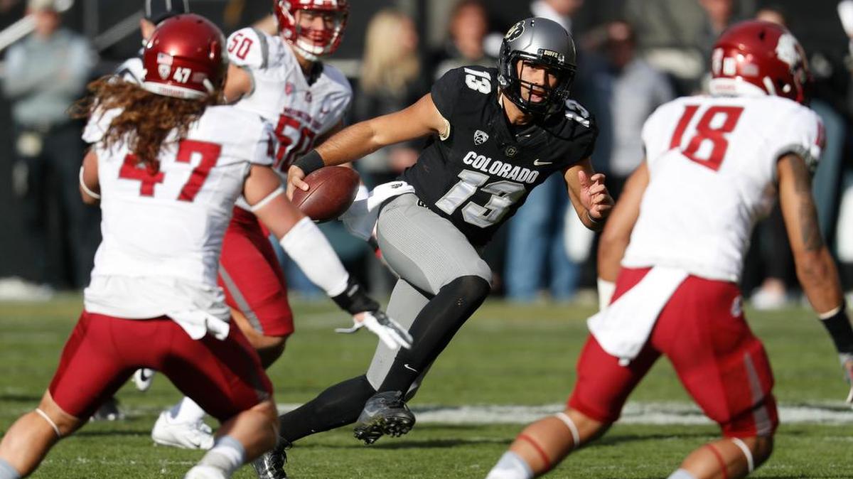 Colorado quarterback Sefo Liufau, center, runs as Washington State’s Peyton Pelluer, Hercules Mata’afa and Shalom Luani close in during a game Saturday in Boulder, Colo.
