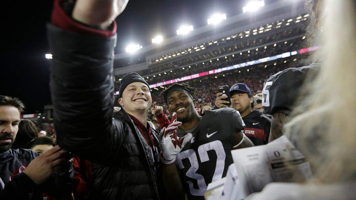 Washington State running back James Williams takes a selfie with a fan after the Cougars beat Oregon 34-20 in Pullman, Wash., Saturday, Oct. 20, 2018.