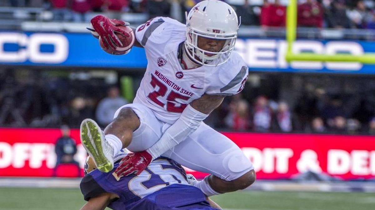 WSU’s Jamal Morrow leaps over UW’s Sidney Jones this past Friday in the first half of the Apple Cup.