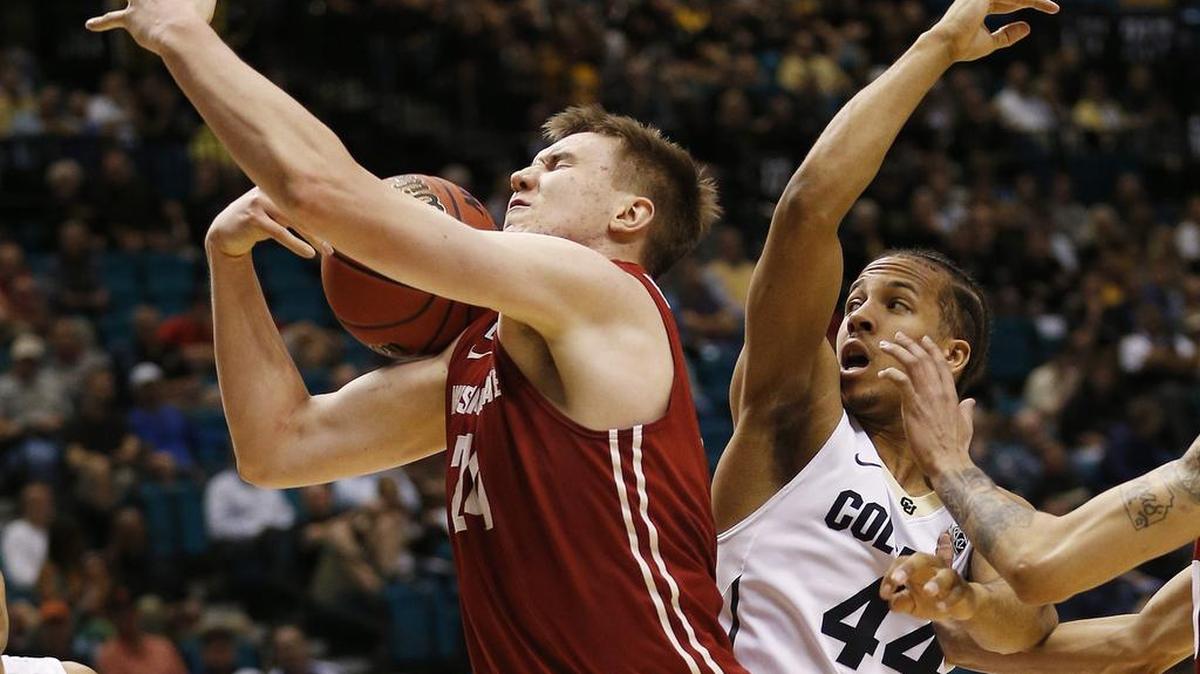 WSU’s Josh Hawkinson, left, and Colorado’s Josh Fortune fight for a rebound in the first half Wednesday in Las Vegas. Hawkinson finished with 14 rebounds.