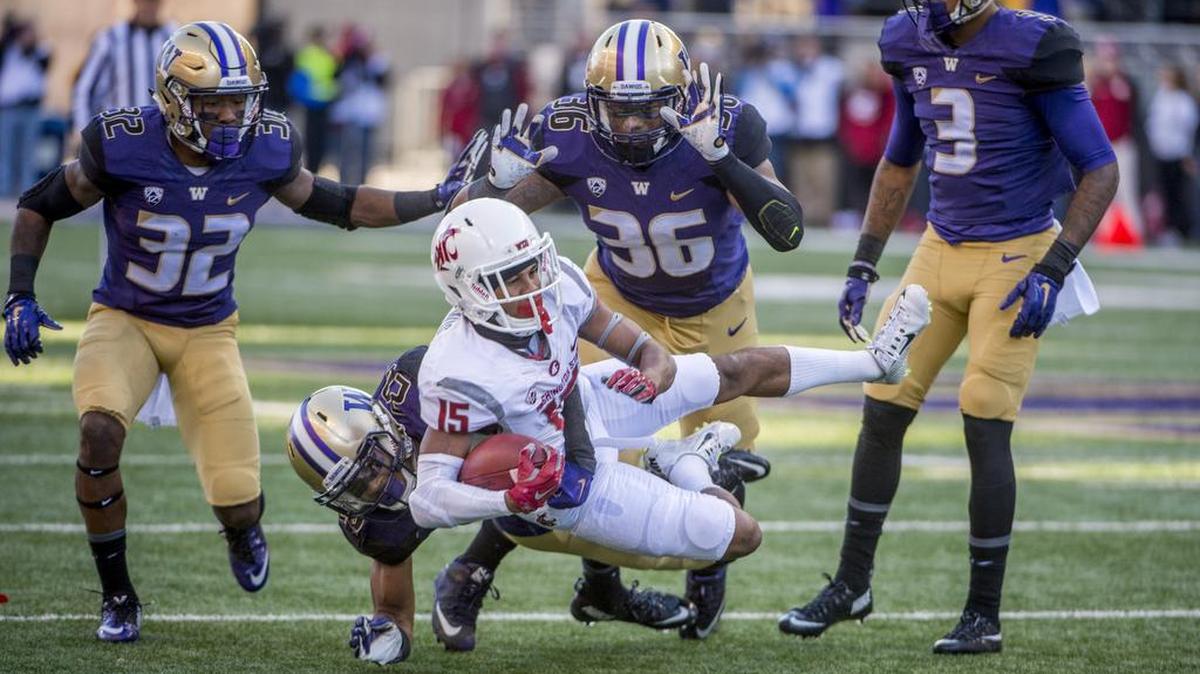 Receiver Robert Lewis of Washington State is thrown down by Washington's Azeem Victor after a short pass in the Apple Cup football game in Husky Stadium, November 27, 2015. UW Huskies beat the WSU Cougars 45-10.