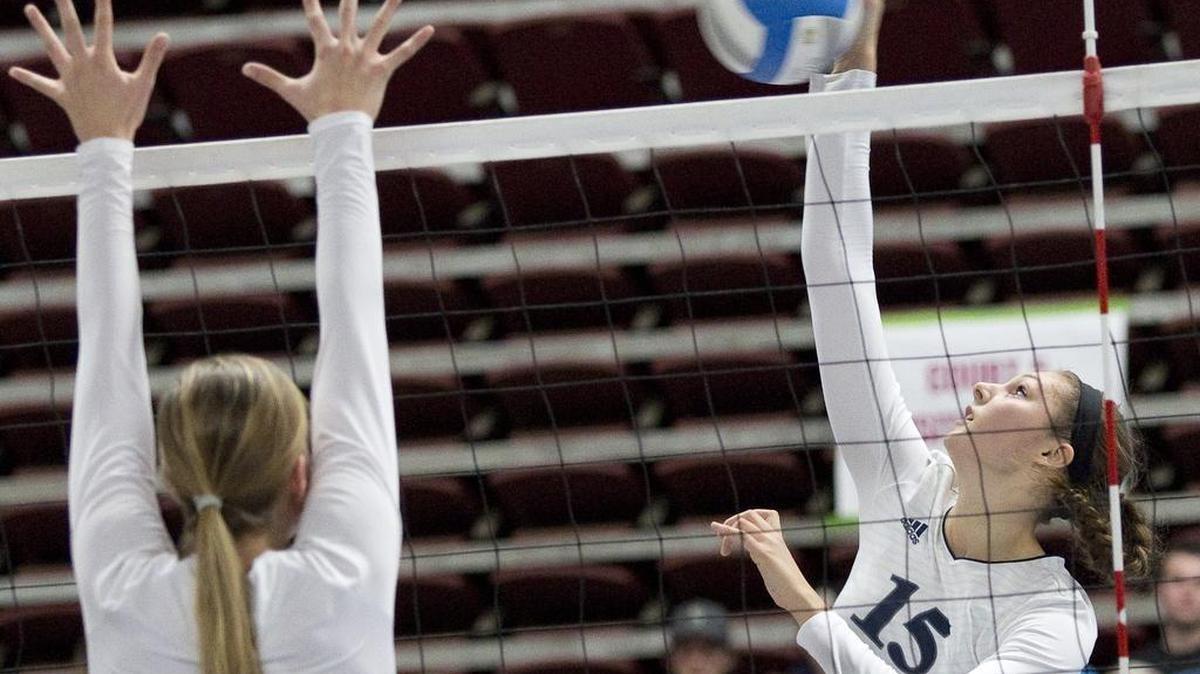 Lynden Christian’s Kara Bajema (15) spikes over Cedar Park Christian’s Madysen Trout (11) in the Class 1A State Volleyball Final Saturday, Nov. 14, at the Yakima Valley SunDome.