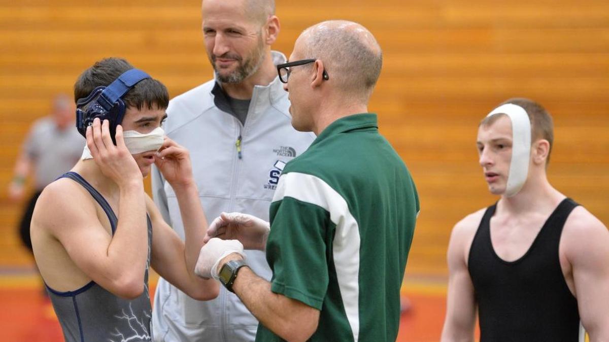 Former Squalicum assistant coach Brian Porteus, center, watches the Storm’s Zach Johnson, left, get his nose taped up at the 2014 Lynden Annual Wrestling Invitational on Saturday, Jan. 25, 2014 in Lynden. Porteus has taken over the United wrestling program, a combination of Sehome, Squalicum and Bellingham wrestlers.