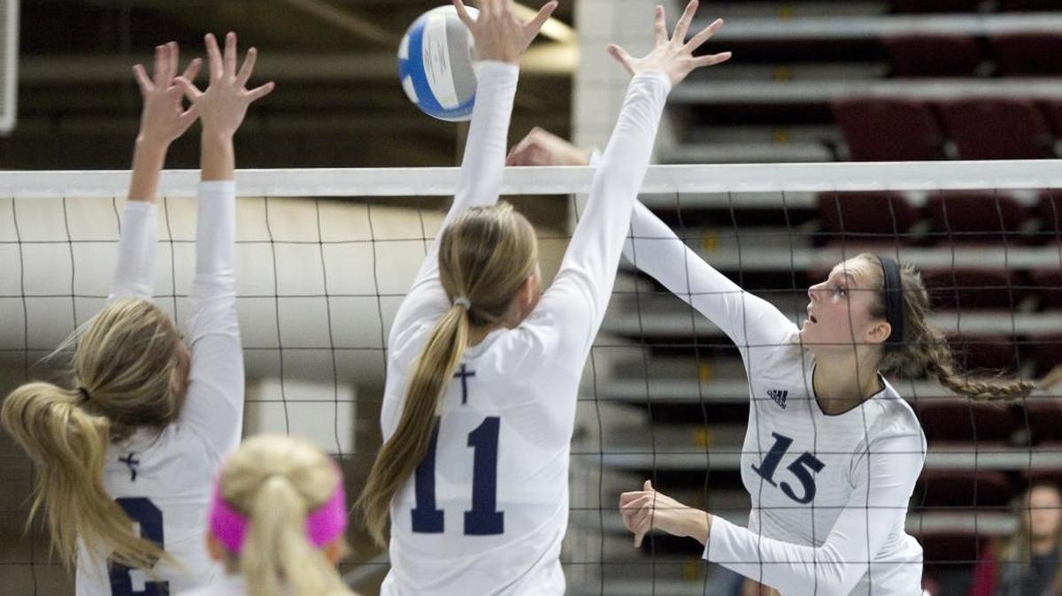 Lynden Christian’s Kara Bajema (15) spikes over Cedar Park Christian’s Albina Melnik (2) and Madysen Trout (11) in the Class 1A State Volleyball Championships Nov. 14 at the Yakima Valley SunDome.