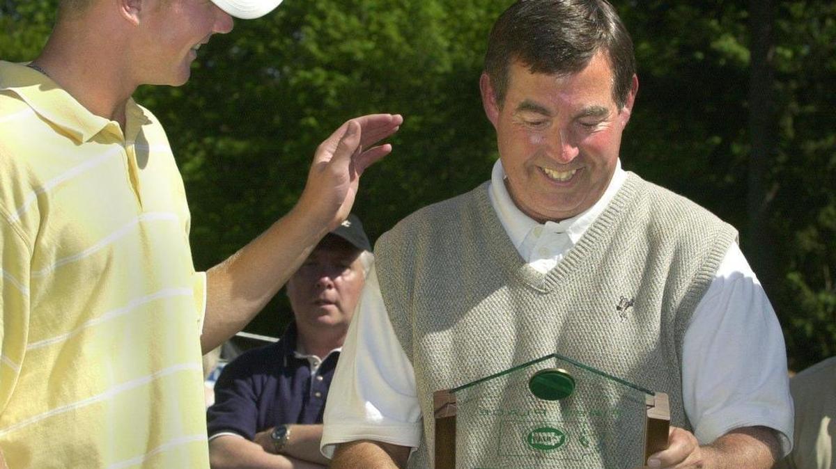 Lynden’s Tim Feenstra pats the back of coach Russ Dorr, who enjoys a special moment holding the first-place team award the Lions won during the 2001 Class 3A Boys’ State Golf Tournament at Lake Padden Golf Course in Bellingham. It was Dorr's first championship as Lynden's coach. Feenstra shot 141 for the tournament to win the state title.