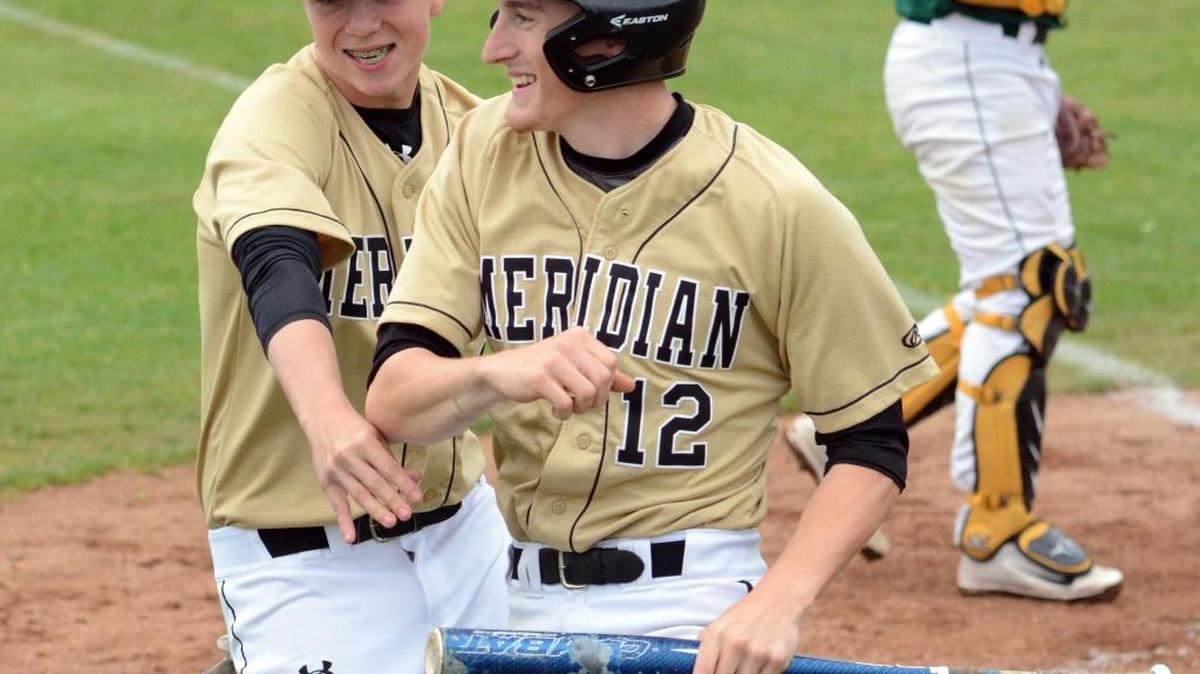 Meridian's Dakota Jones (12) celebrates scoring a run with teammate Tyler Linderman during a Class 1A State Tournament regional game against Vashon Island on Saturday, May 21, at Castle Rock High School.