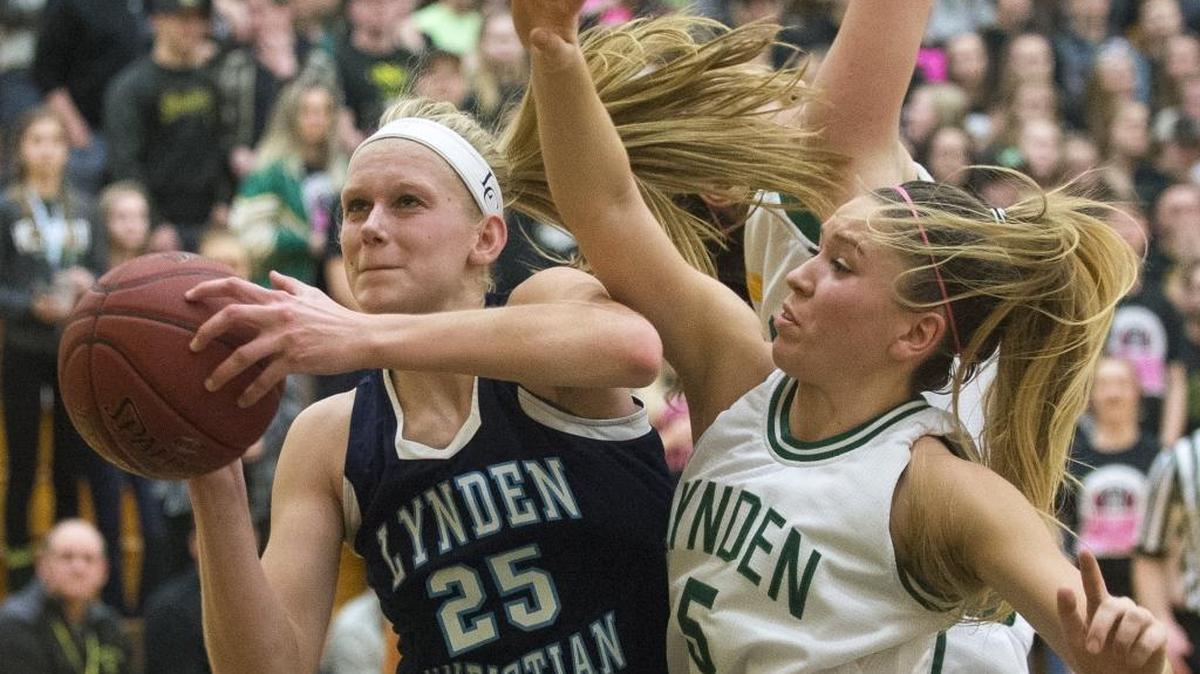 Lynden Christian’s Sam Van Loo scores after getting an offensive rebound as Lynden's Jasmyne Neria, right, plays defense Jan. 19 at Lynden High School in Lynden. Lynden Christian won 56-53.