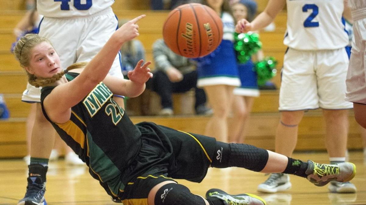 Lynden’s Elisa Kooiman passes the ball to a teammate as she falls out of bounds during a 67-39 victory over Liberty Feb. 27 at Renton High School. Kooiman signed a national letter of intent to play basketball for Northwest Nazarene University.