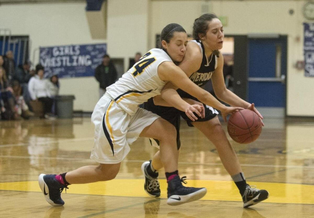 Meridian’s Kyrin Baklund, right, battles Burlington-Edison’s Annaleis Reyes for a loose ball on Thursday, Feb. 2, in Burlington. Burlington-Edison defeated Meridian, 77-47.