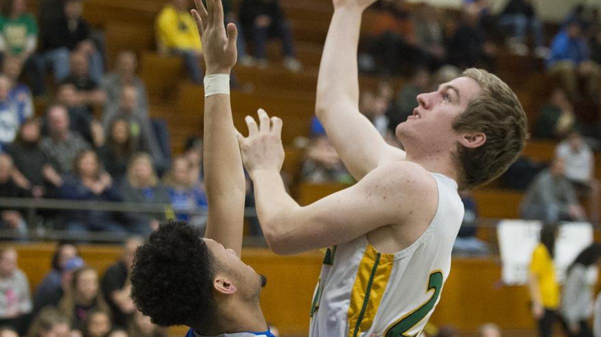 Lynden's Andrew Kivlighn shoots and scores over Olympic's Jaiden Mosley on Saturday, Feb. 25, at Mount Vernon High School.
