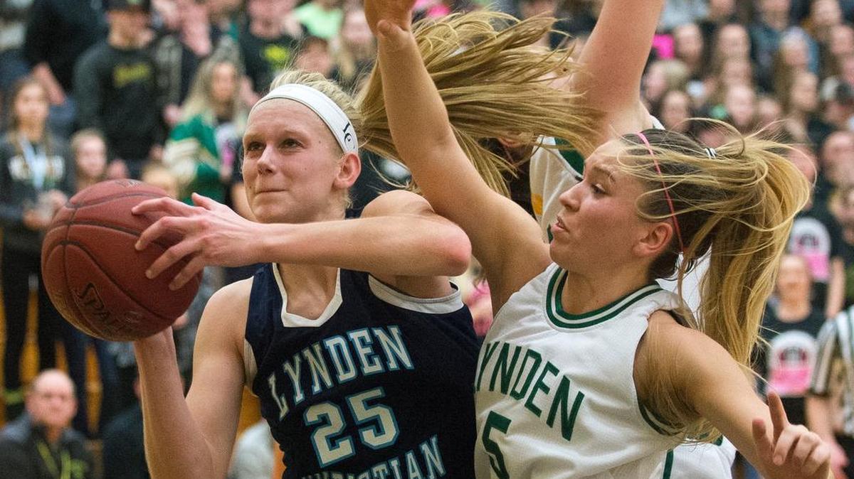 Lynden Christian’s Sam Van Loo scores after getting an offensive rebound as Lynden’s Jasmyne Neria defends. Van Loo scored 12 points.