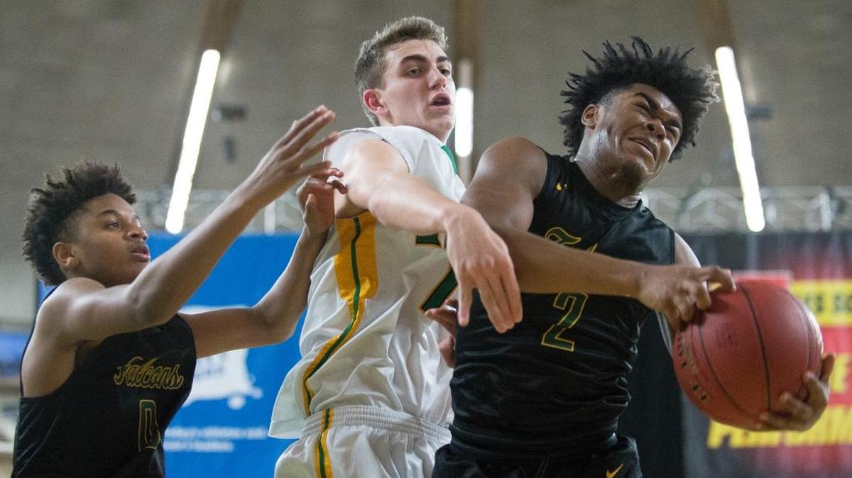 Foss’ Demetrius Crosby II, right, grabs a rebound in front of Lynden’s Clayton Whitman, center, and his teammate Damani Kelly in a Class 2A state semifinal game on Friday, March 3, at the Yakima Valley SunDome in Yakima. Lynden lost, 54-51, and will play for third place on Saturday.